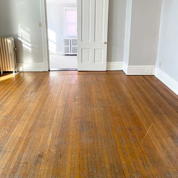 a room with a wooden floor and white walls.