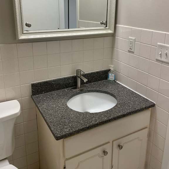 a bathroom with a sink, mirror and toilet.