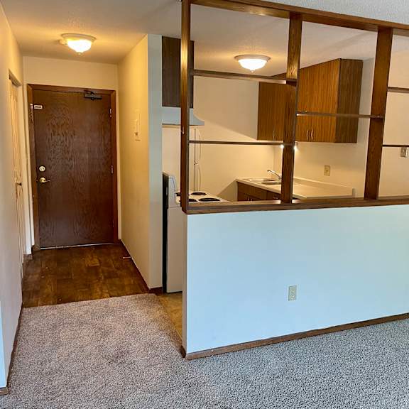 a room with a brown door and a white wall.
