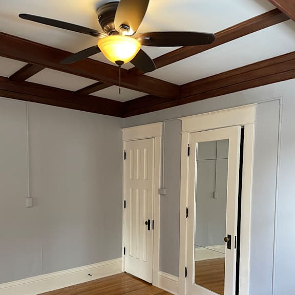 a ceiling fan with a light fixture hangs over a white ceiling.
