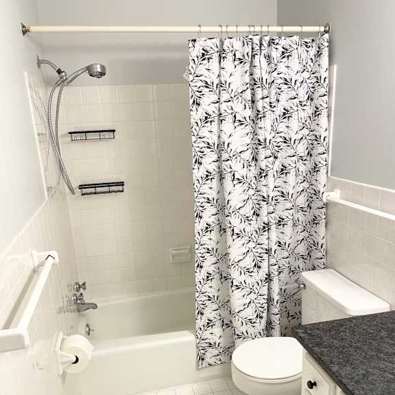 comfortably-sized bathroom with ceramic tiled floor, shower and walls.