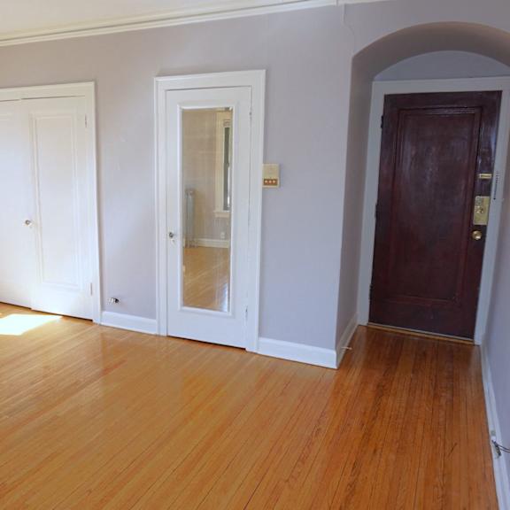 a room with a wooden floor and three doors.
