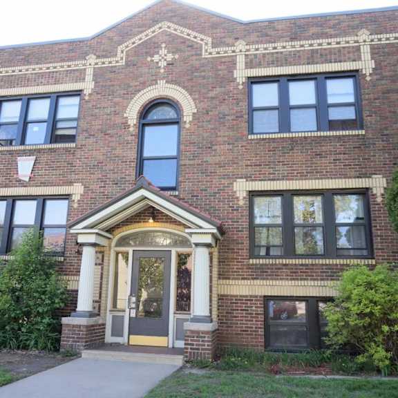 a red brick building with a large arched window and a doorway.