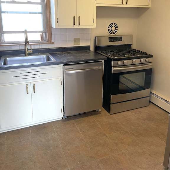 a kitchen with wooden floors and white cabinets.