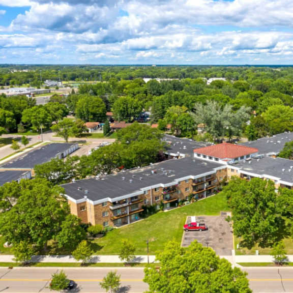 a large building surrounded by trees and a parking lot.