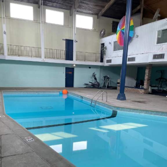a large indoor swimming pool with a blue tiled edge.