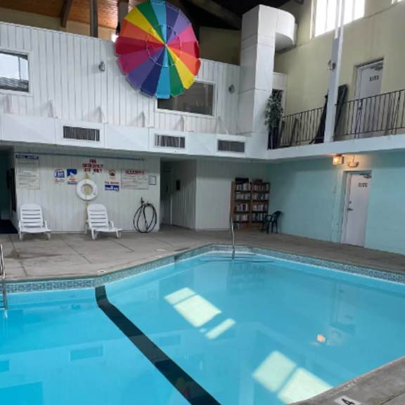 a large indoor swimming pool with a colorful umbrella above it.