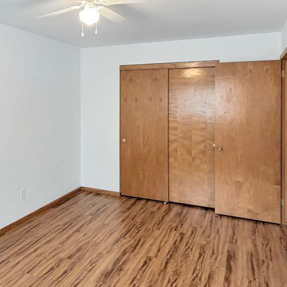 a room with a wooden floor and a wooden wardrobe.