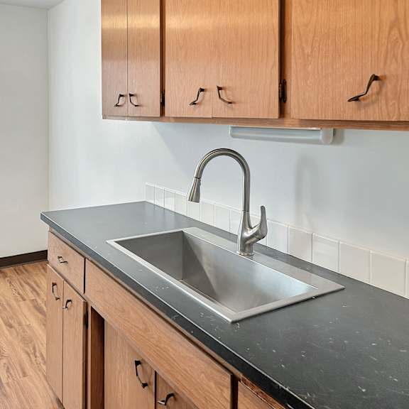 a kitchen with a sink and wooden cabinets.
