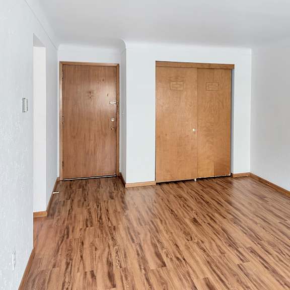 a room with two wooden doors and wooden flooring.