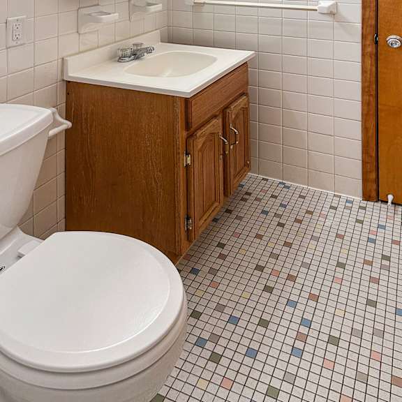 a white toilet sits next to a sink in a small bathroom.