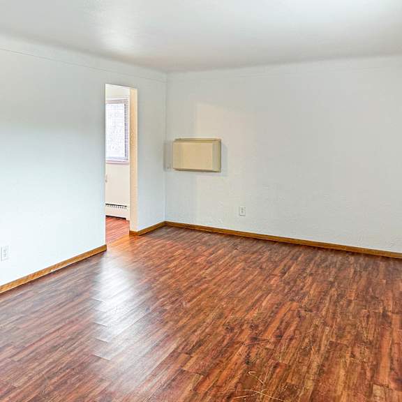 a room with wooden floors and white walls.
