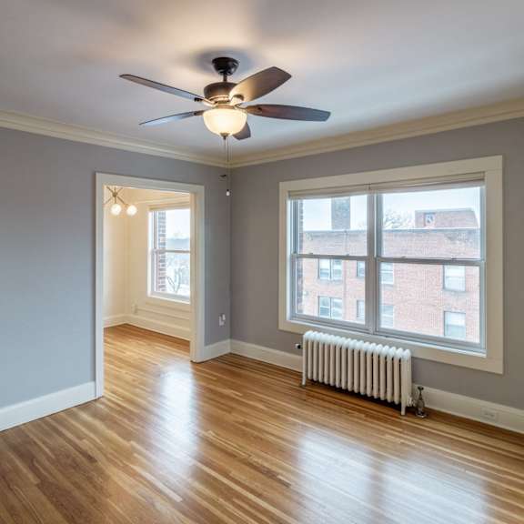 a room with a ceiling fan and a window.
