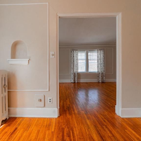 a room with a white radiator and wooden floors.