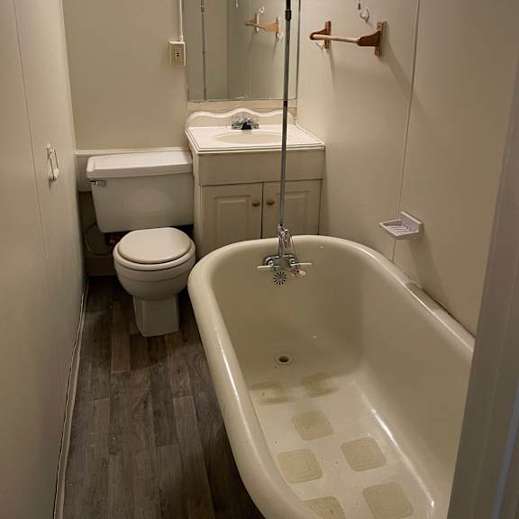 a white bathroom with a white toilet, sink, and bathtub.