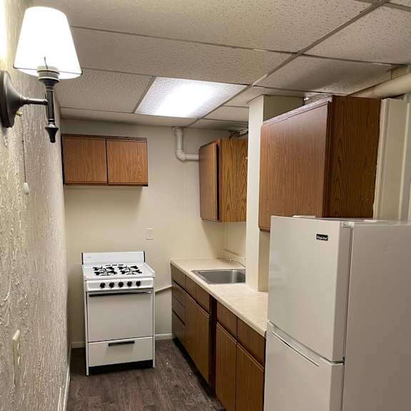 a small kitchen with a white refrigerator and a white stove.