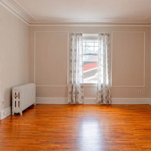 a room with wooden floors and a white radiator.