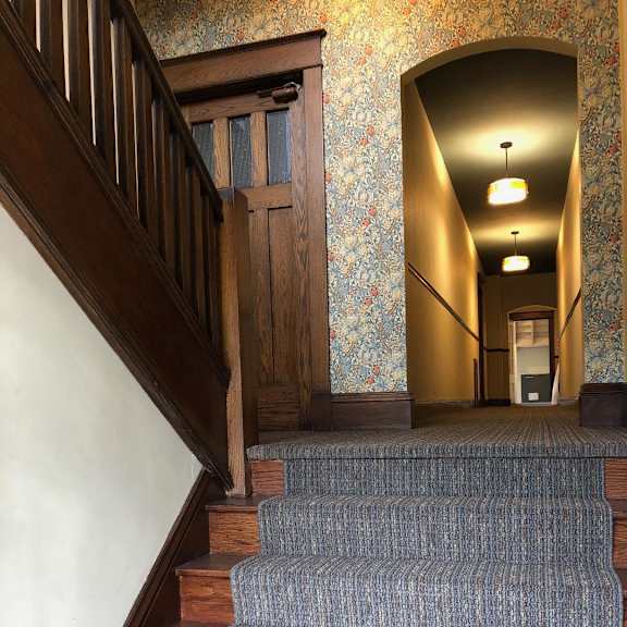 a staircase with a carpeted runner and wooden steps.