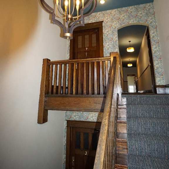 a staircase with a chandelier hanging above it.