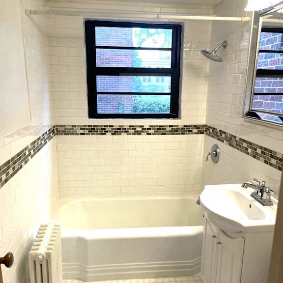 a white bathroom with a tub, toilet, and sink.