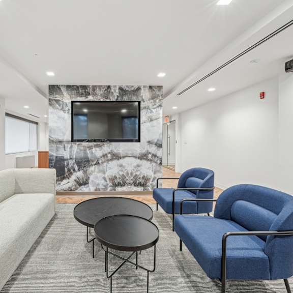 a living room with a grey couch, a blue chair, and a black table at sherwood at southern towers, alexandria, 22311