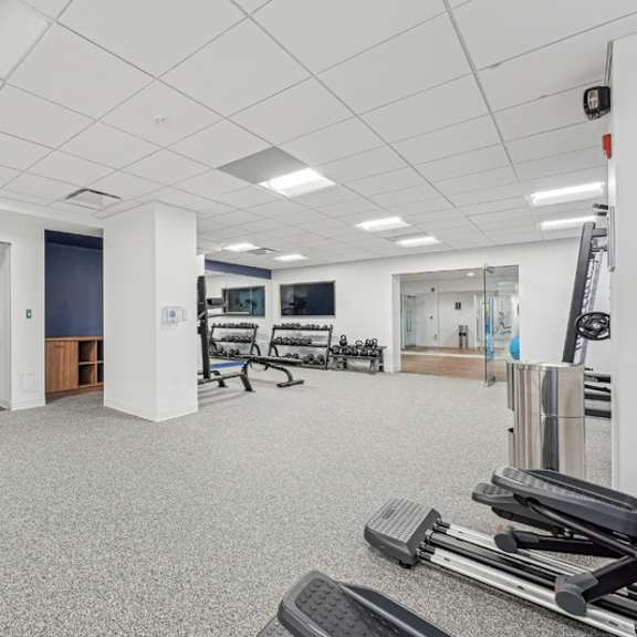 a gym with a variety of equipment including treadmills, weights and exercise machines at sherwood at southern towers, alexandria, 22311