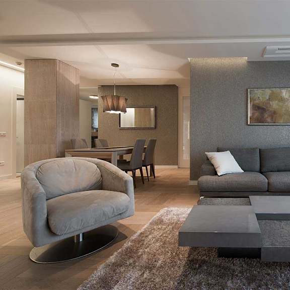 a modern living room with a grey sofa and a grey armchair.