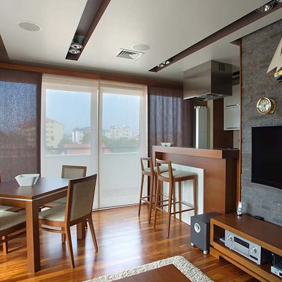 a living room with a television and a dining table.