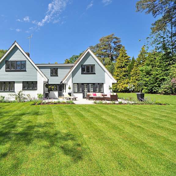 a large house with a green lawn in front.