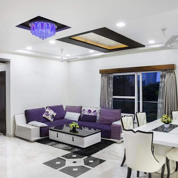 a modern living room with a purple couch and a white dining table.