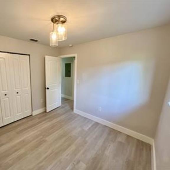 a room with a white door and a light brown floor.