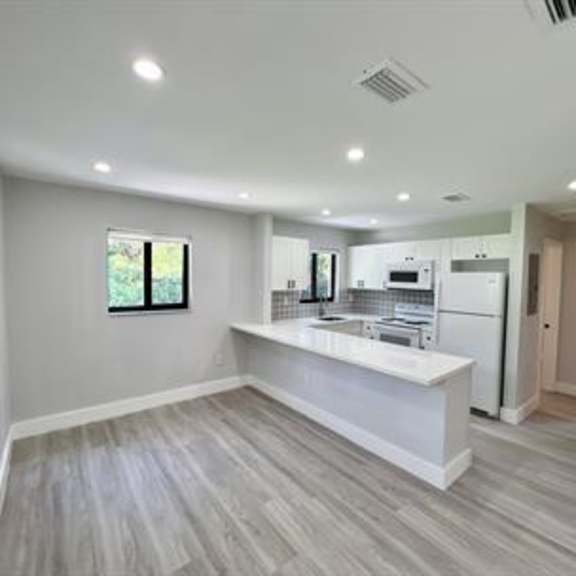 a kitchen with white appliances and a window.