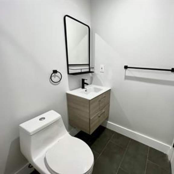 a white toilet sits next to a sink in a small bathroom.