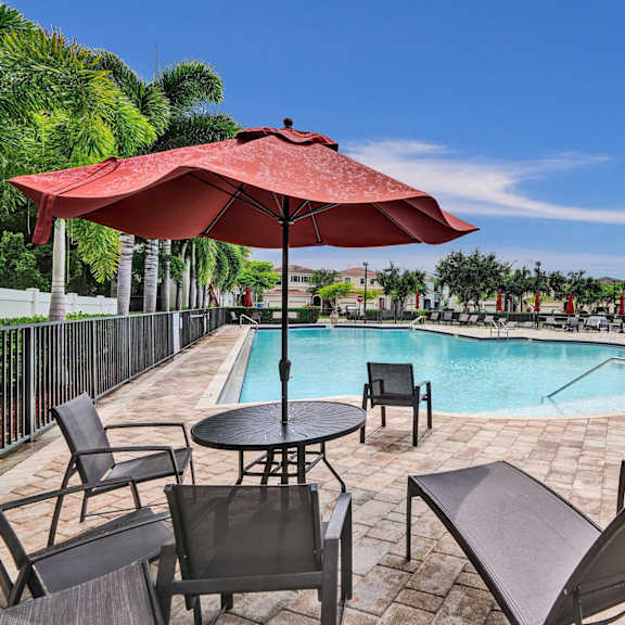 community pool with chase lounges and dining furniture.
