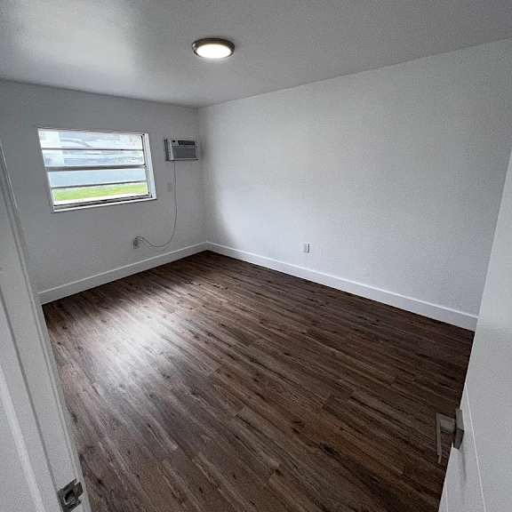 a room with wooden flooring and a window.