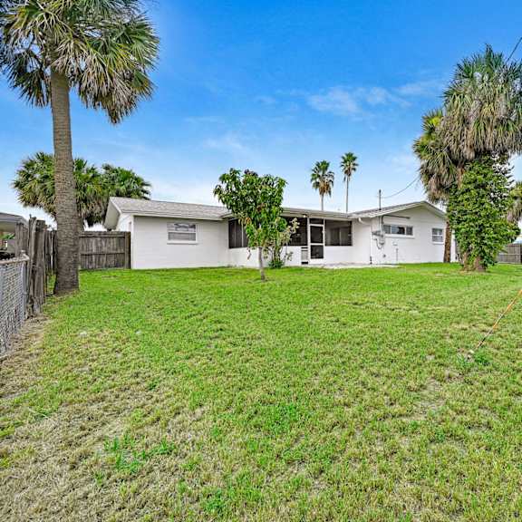 a house with a white fence and a green lawn.