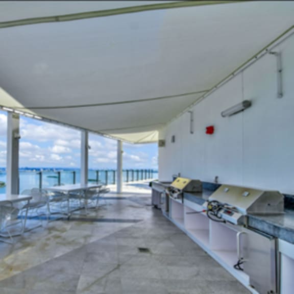 a patio with a table and chairs overlooking a body of water.