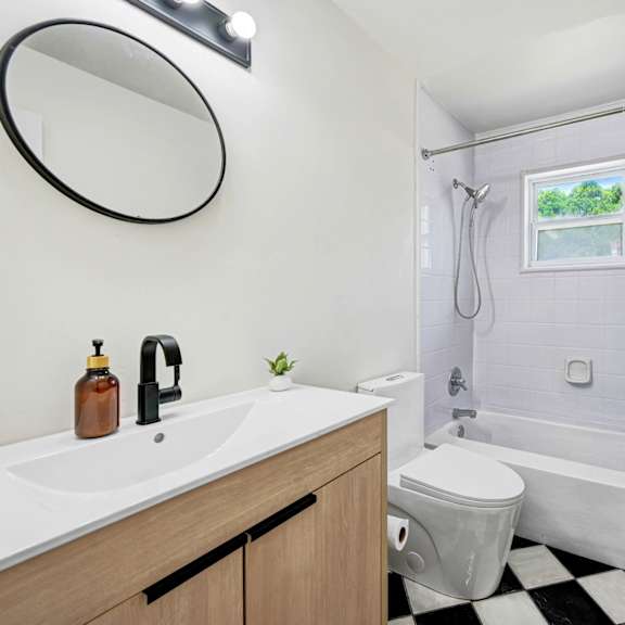 a bathroom with a white sink and a black and white checkered floor.