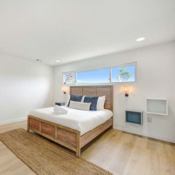 a bedroom with a bed, chair, and window.