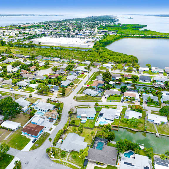 a bird's eye view of a residential area with houses, roads, and a body of water.