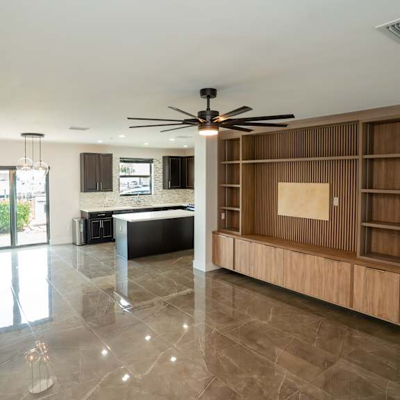 a spacious room with a ceiling fan and a large wooden cabinet.
