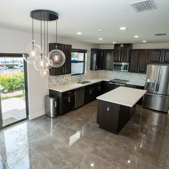 a modern kitchen with a marble countertop and stainless steel appliances.