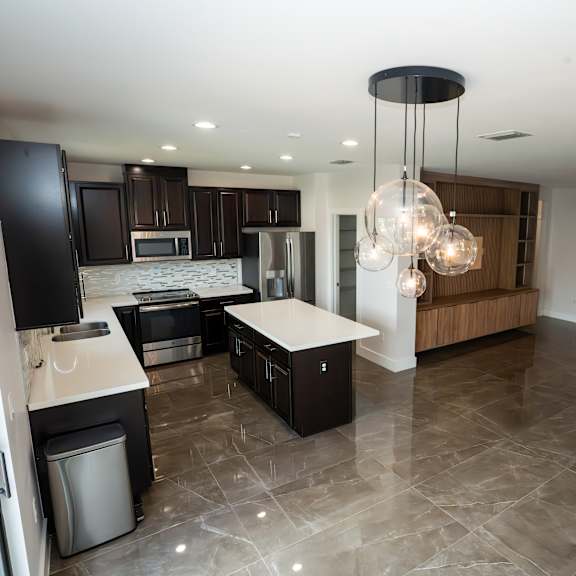 a modern kitchen with a black refrigerator and a wooden island.
