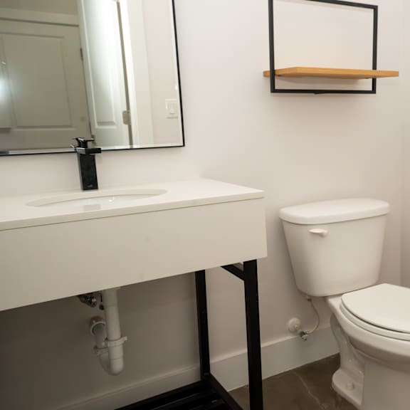 a white toilet sits next to a white sink in a bathroom.