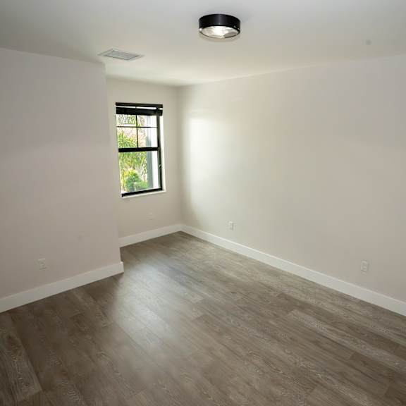 a room with a window and wooden flooring.