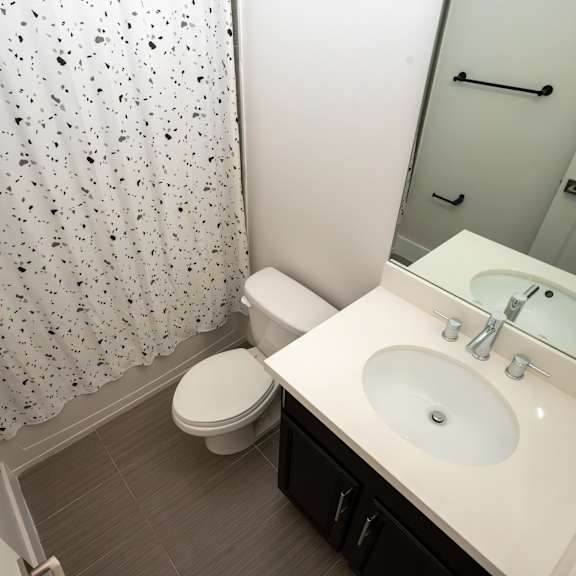 a white toilet sits next to a sink in a small bathroom.
