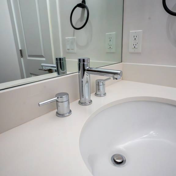a white sink with a silver faucet and a silver soap dish.