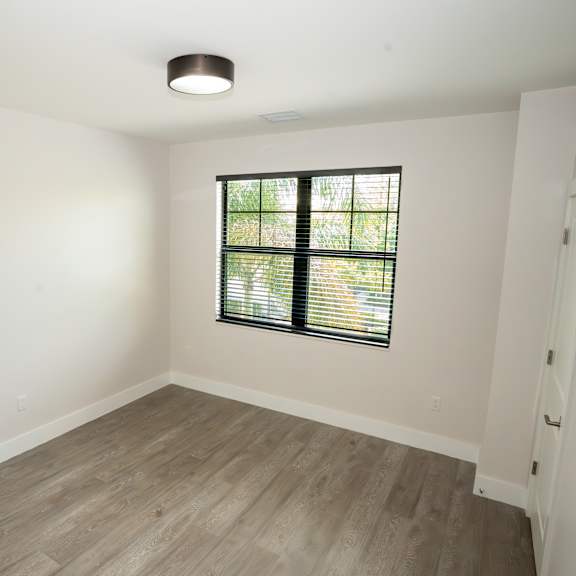 a room with a window and wooden flooring.