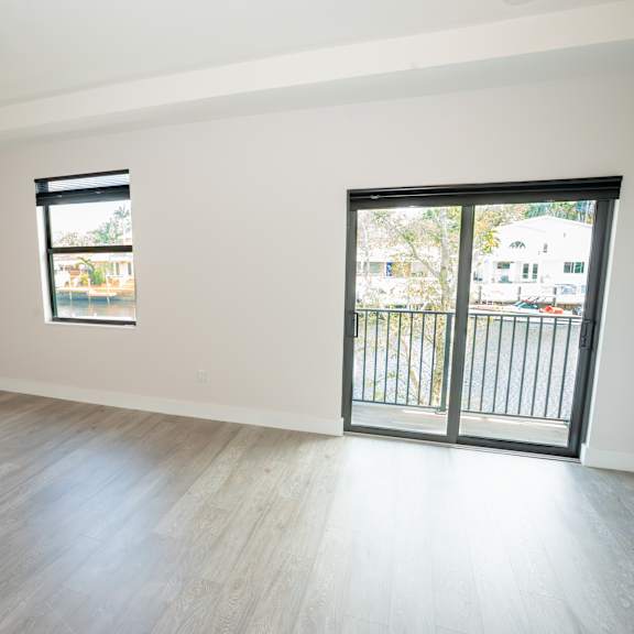 a room with a ceiling fan and sliding glass doors.