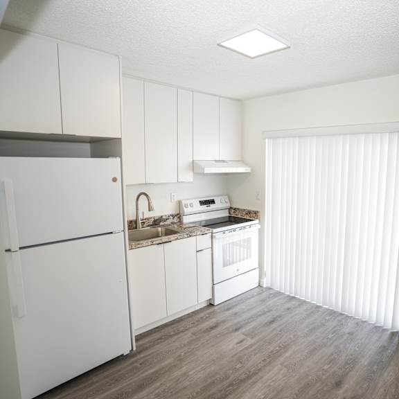 a kitchen with white cabinets and a refrigerator.